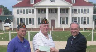 District 23 presents a check to American Village